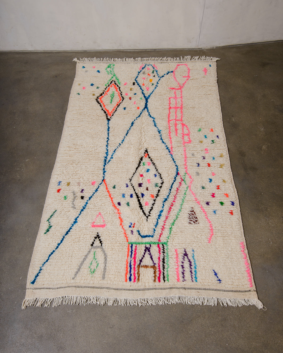 Berberlin Azilal rug made of fluffy wool and cotton, laying flat on a concrete floor.